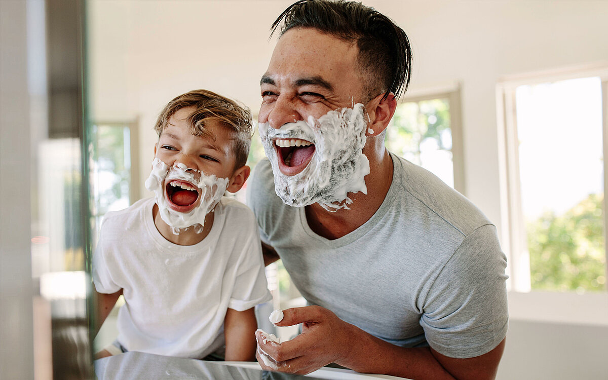 Vater und Sohn rasieren sich gemeinsam vor dem Spiegel 